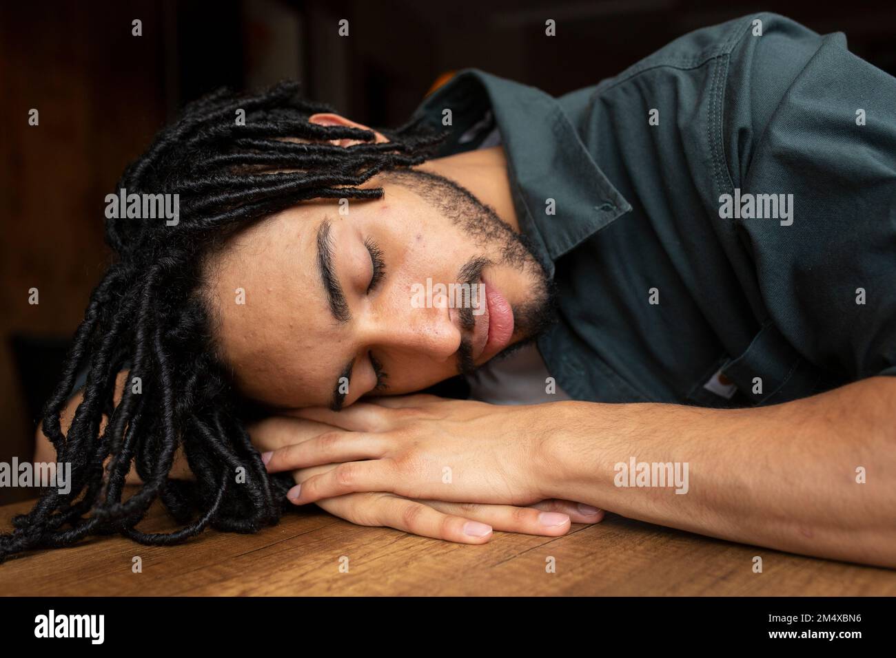 Homme dormant à la table à la maison Banque D'Images