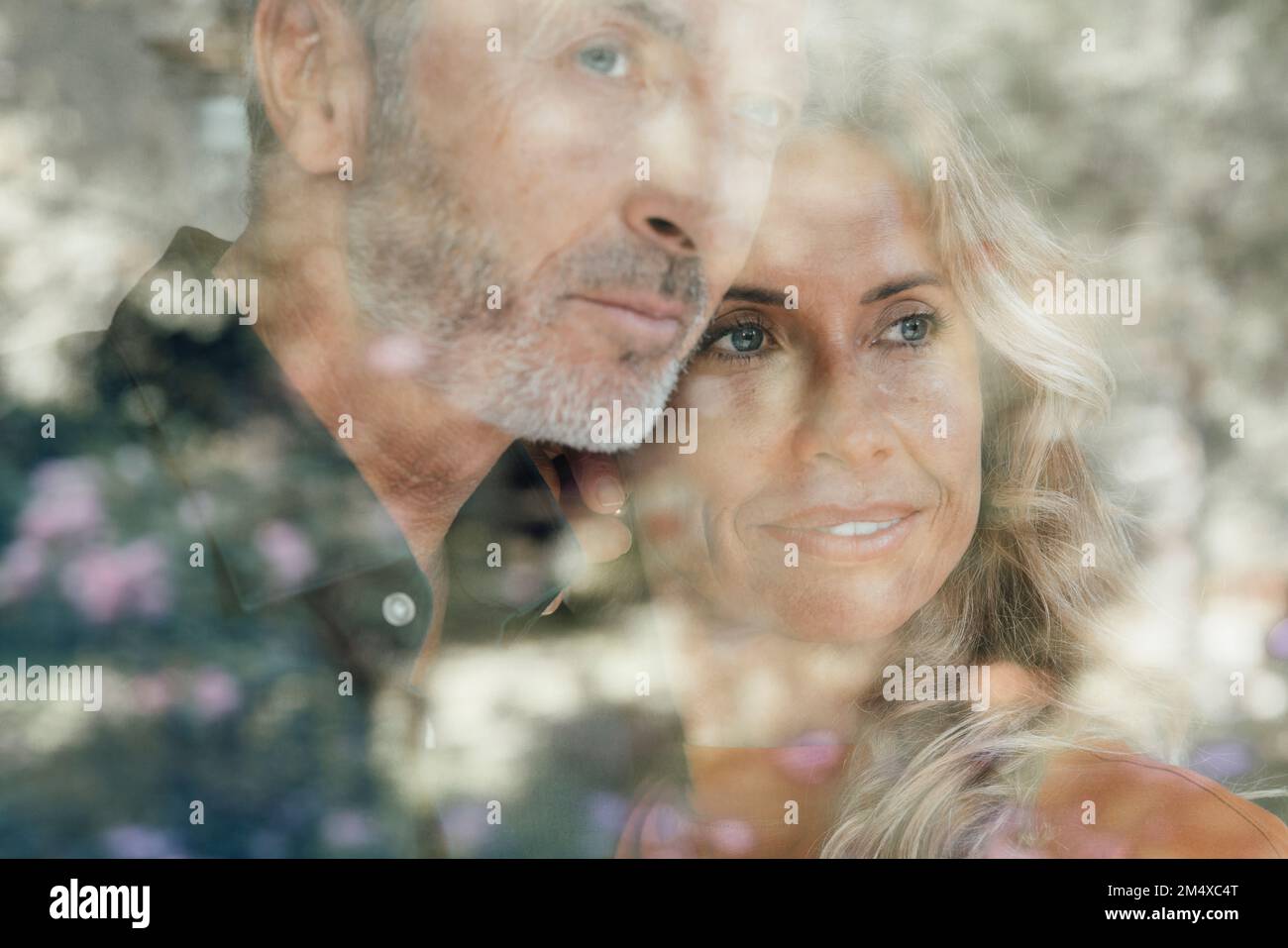 Homme et femme attentionnés vus par une fenêtre en verre Banque D'Images
