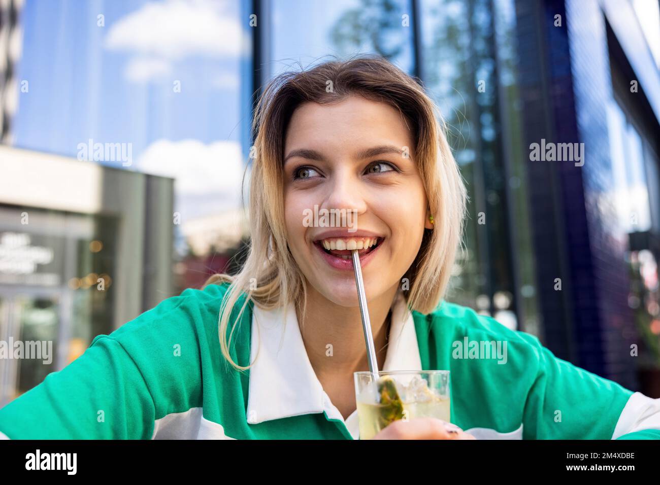 Bonne femme à boire avec de la paille en acier inoxydable Banque D'Images