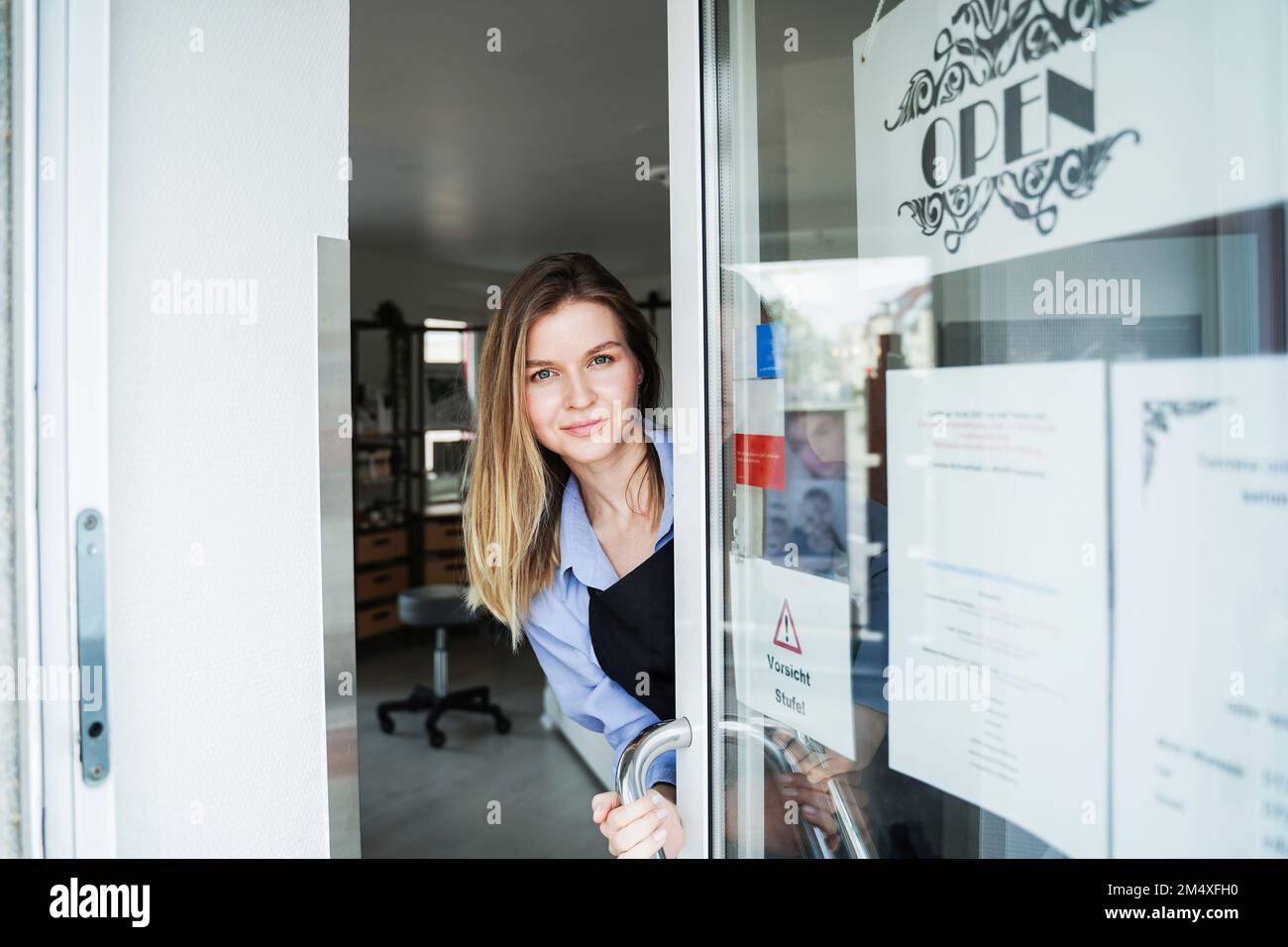 Coiffeur souriant, à la porte du salon Banque D'Images
