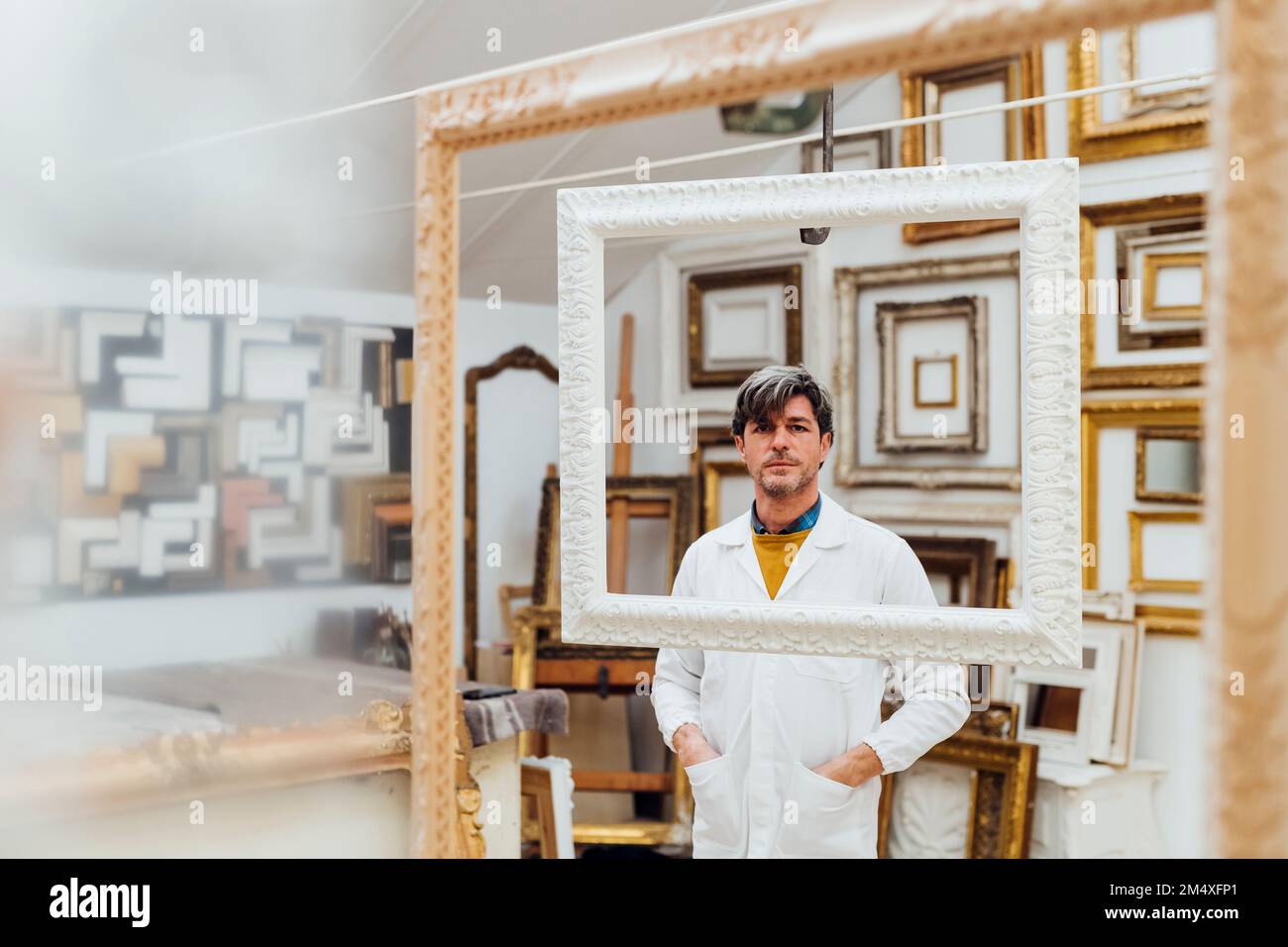 Artisan mature debout avec les mains dans les poches à l'atelier Banque D'Images