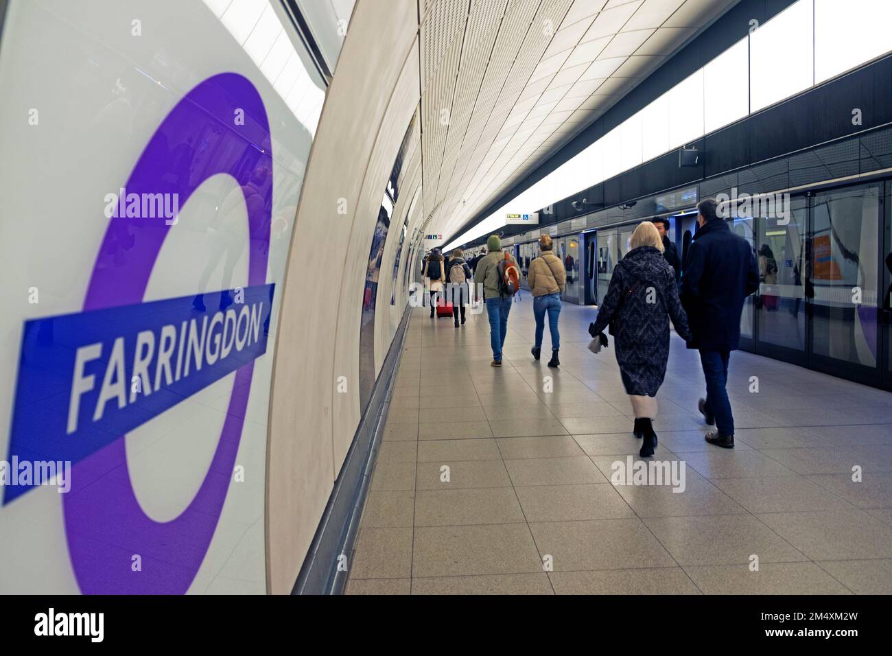 Panneau Farringdon TFL sur le mur de la station de métro Elizabeth Line et derrière les personnes marchant sur la plate-forme Londres Angleterre UK KATHY DEWITT Banque D'Images