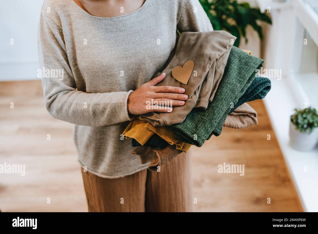 Jeune designer de mode avec des vêtements pliés dans l'atelier Banque D'Images