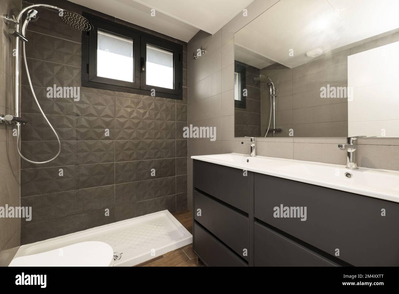 Salle de bains moderne et design avec douche à l'italienne sans écran, double lavabo en porcelaine blanche et miroir sans cadre au mur Banque D'Images