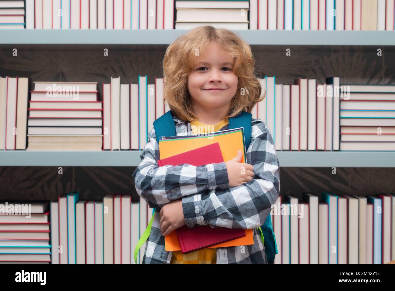 Garçon d'école avec des livres dans la bibliothèque. Concept d'école et d'éducation. Portrait d'un enfant garçon scolaire mignon. Retour à l'école. Banque D'Images