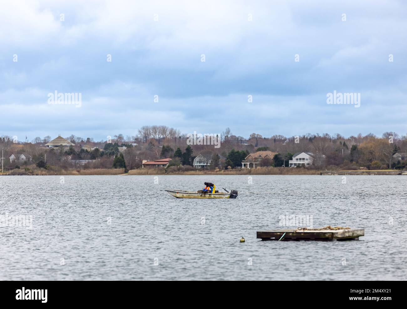 Homme pêche sur un petit bateau dans le lac montauk Banque D'Images