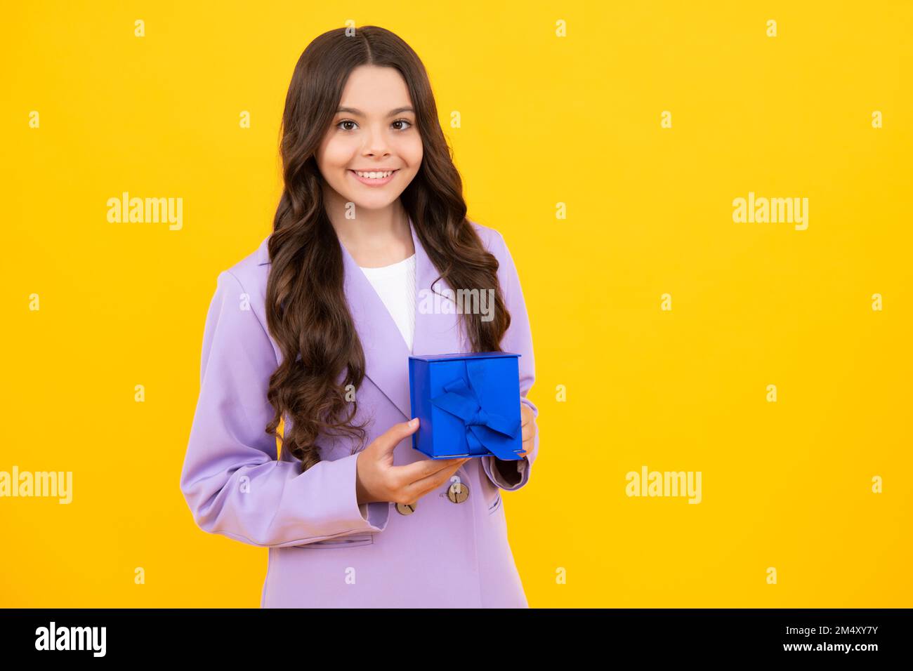 Bonne adolescente, émotions positives et souriantes de la jeune fille. Enfant de 12-14 ans avec cadeau sur fond isolé. Anniversaire, concept de vacances Banque D'Images