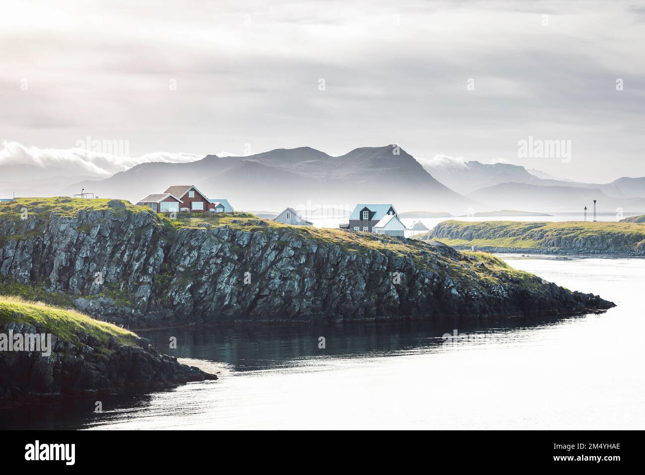 Brouillard sur la mer dans la ville de Stykkisholmskirkja en Islande, maisons colorées au bord de la falaise Banque D'Images