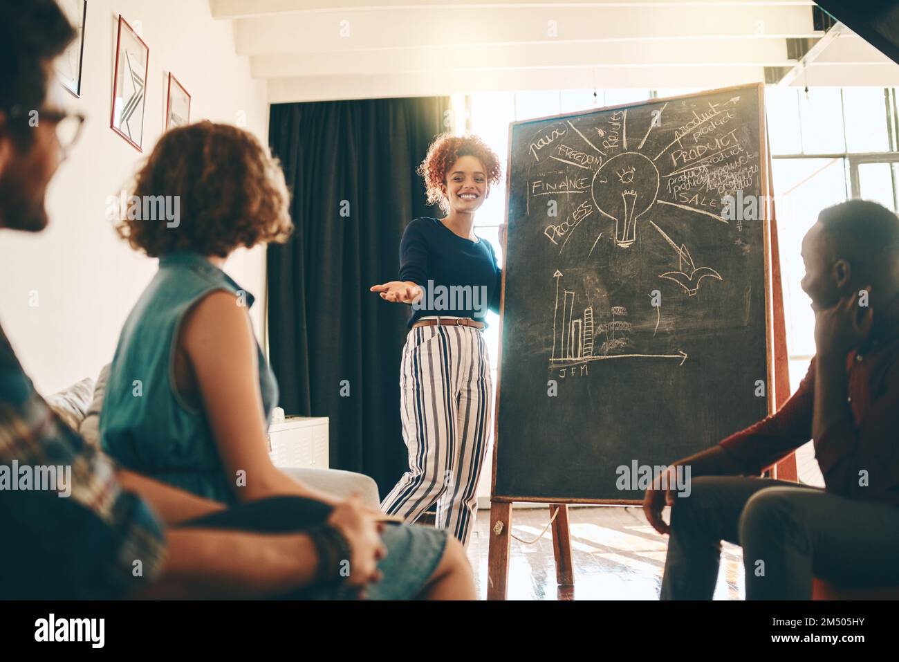 Garder toutes leurs idées grandes et audacieuses. une femme d'affaires qui donne une présentation à ses collègues dans un bureau. Banque D'Images