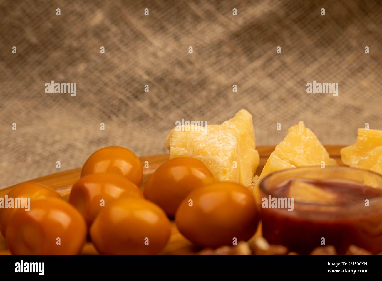 Diverses variétés de fromage, de noix et d'œufs de caille fumés sur une surface en bois. Banque D'Images