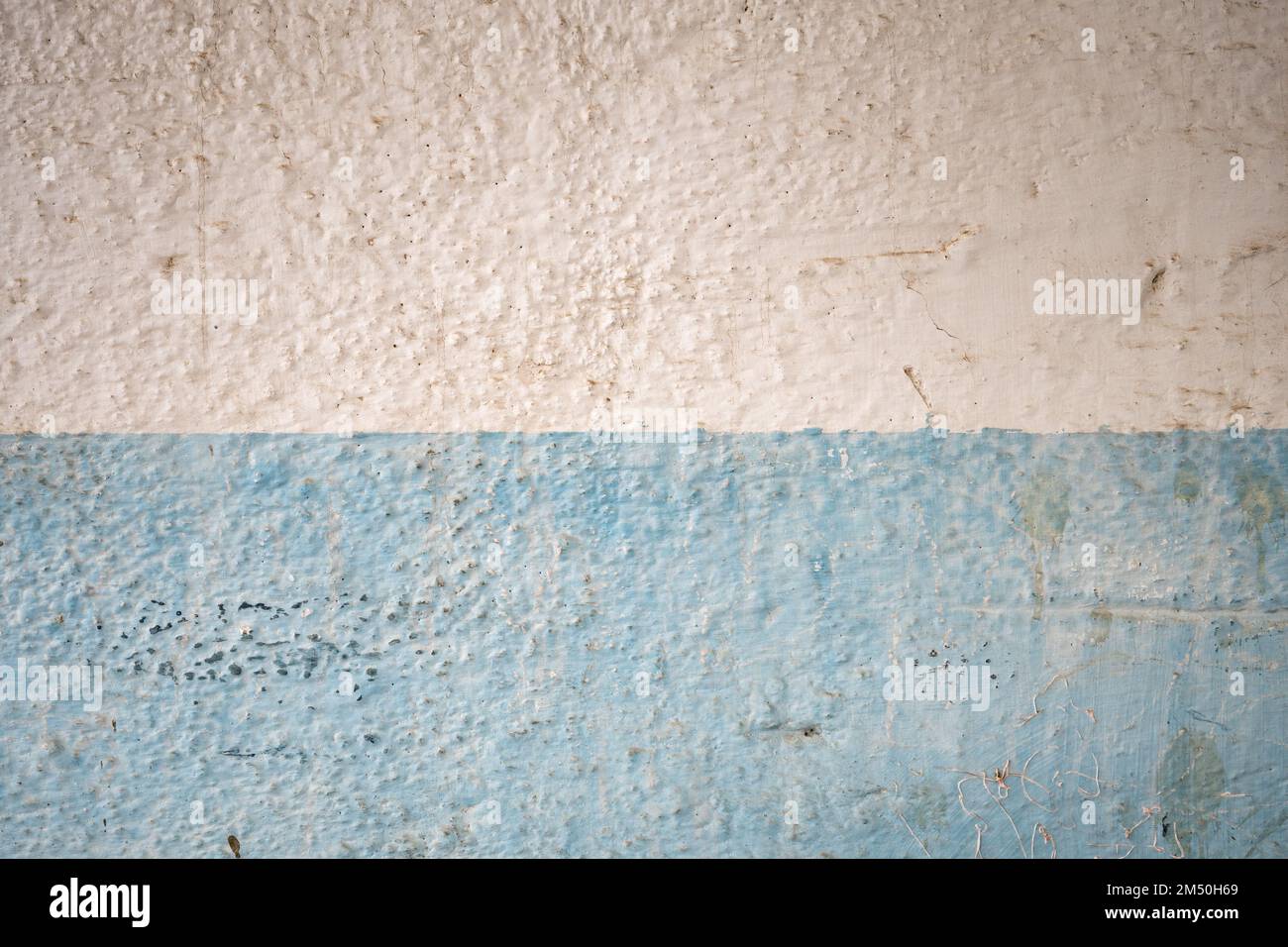 Fragment d'un mur sale peint en bleu-blanc Banque D'Images