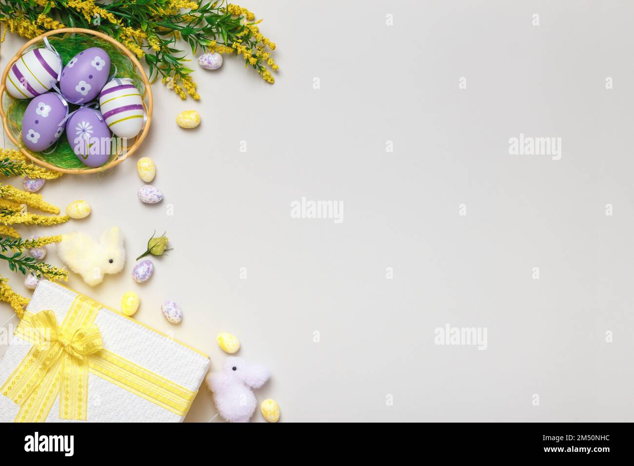 Composition de Pâques. Vue de dessus oeufs dans le panier fleurs cadeau sur fond gris Banque D'Images
