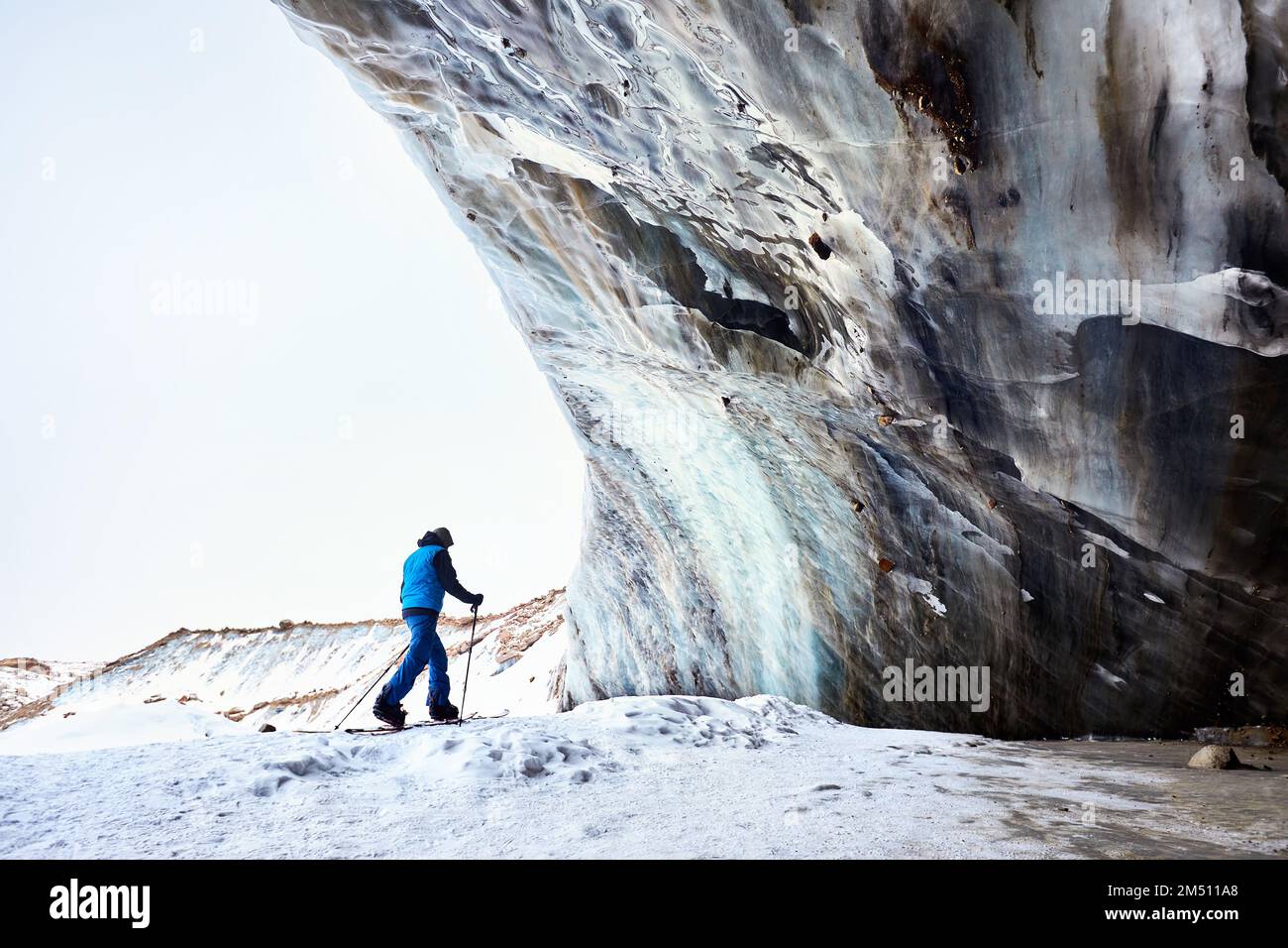 Skieur homme ski de randonnée à la station de ski de montagne haute neige de Shymbulak près de la paroi de la grotte de glace. Sport en plein air dans l'arrière-pays en hiver. Banque D'Images