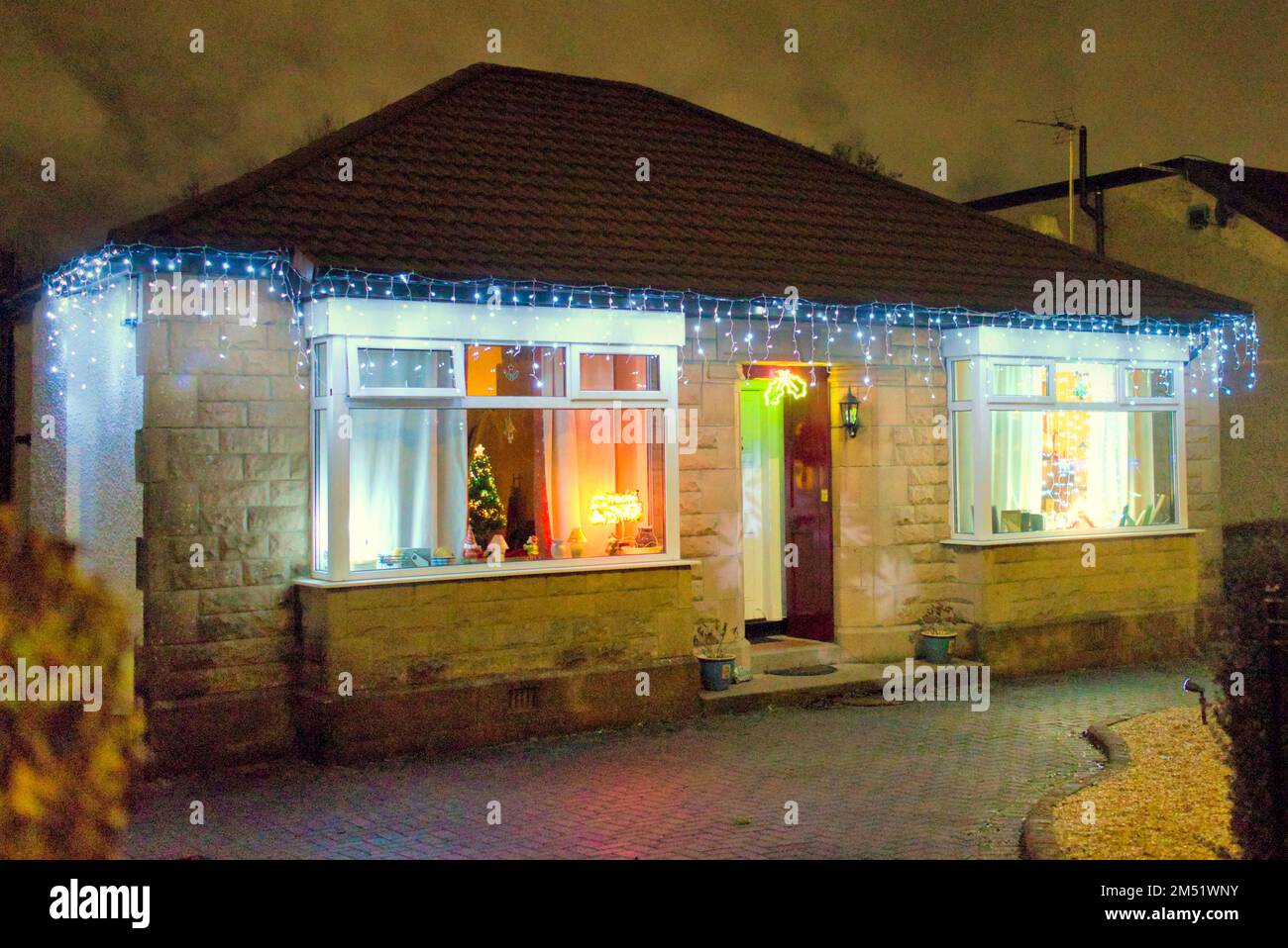 Les lumières de Noël sur le bungalow suburbain des années 1930 construit par john Lawrence aspirante classe moyenne sur la grande route de l'Ouest A82 Glasgow, Écosse, Royaume-Uni Banque D'Images