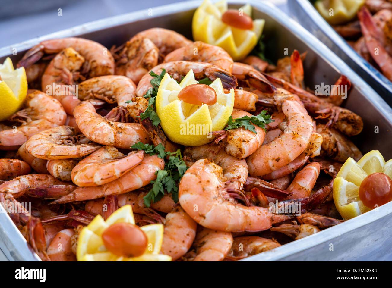 Image de stock de crevettes garnies de citron et servies lors d'un buffet extérieur. Banque D'Images