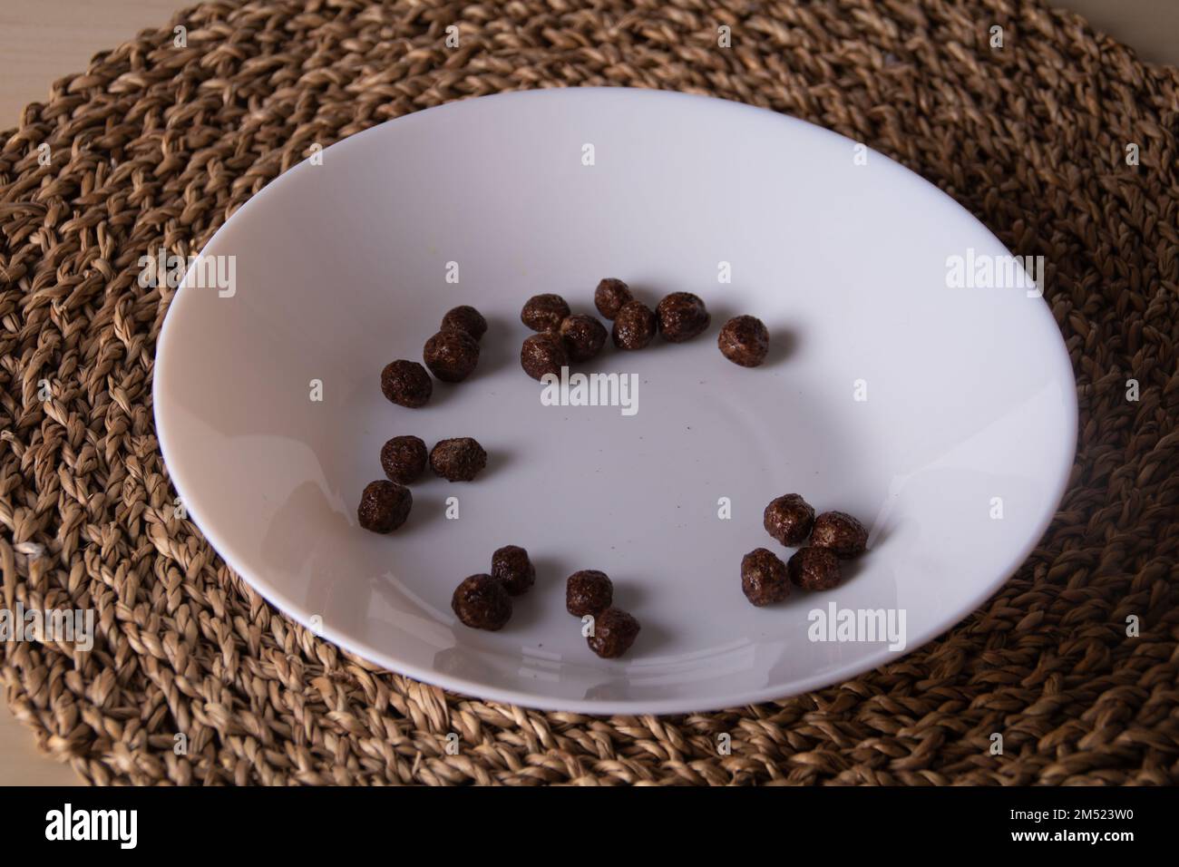 photo de plusieurs petites boules de chocolat sur une assiette blanche sur une base en osier Banque D'Images