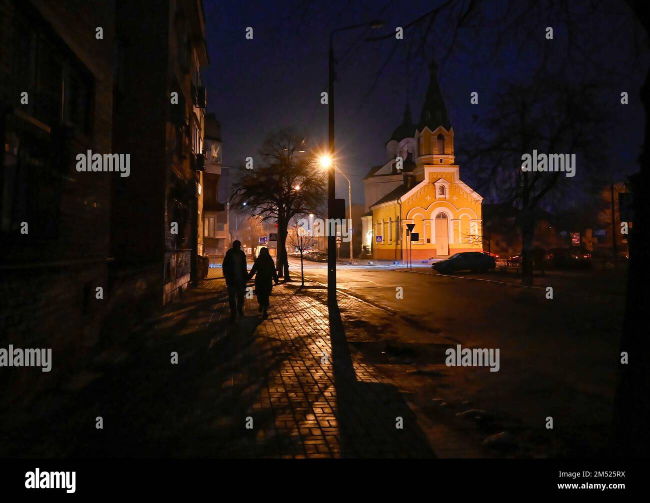 Kiev, Ukraine. 24th décembre 2022. Les gens descendent une rue sombre pendant une panne de courant à Kiev. L'armée russe a mené des attaques massives de roquettes et de drones kamikaze sur les infrastructures énergétiques ukrainiennes. Après de graves dommages au réseau électrique dans de nombreuses villes d'Ukraine, la compagnie nationale d'électricité Ukrenergo a introduit des coupures d'électricité d'urgence et toutes les heures. (Photo par Sergei Chuzavkov/SOPPA Images/Sipa USA) crédit: SIPA USA/Alay Live News Banque D'Images