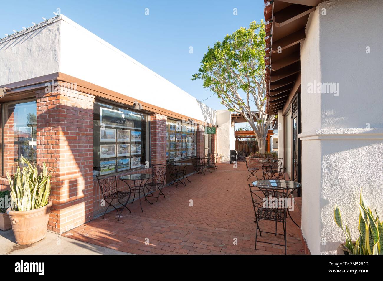 Chaises et tables dans une allée à côté d'un bureau immobilier à Rancho Santa Fe, Californie Banque D'Images