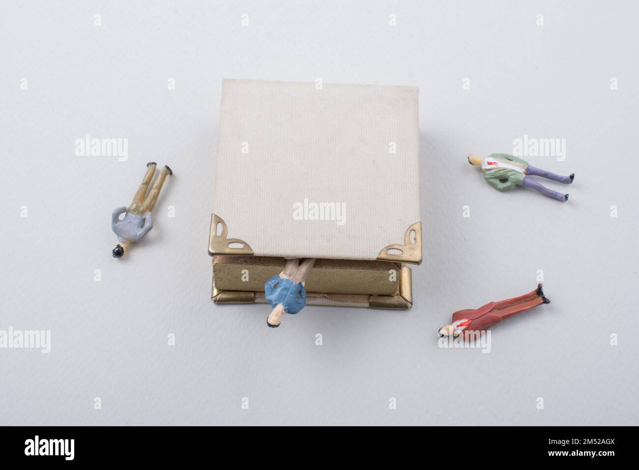 Petite figurine d'hommes modèles trouvés à côté d'un livre Banque D'Images