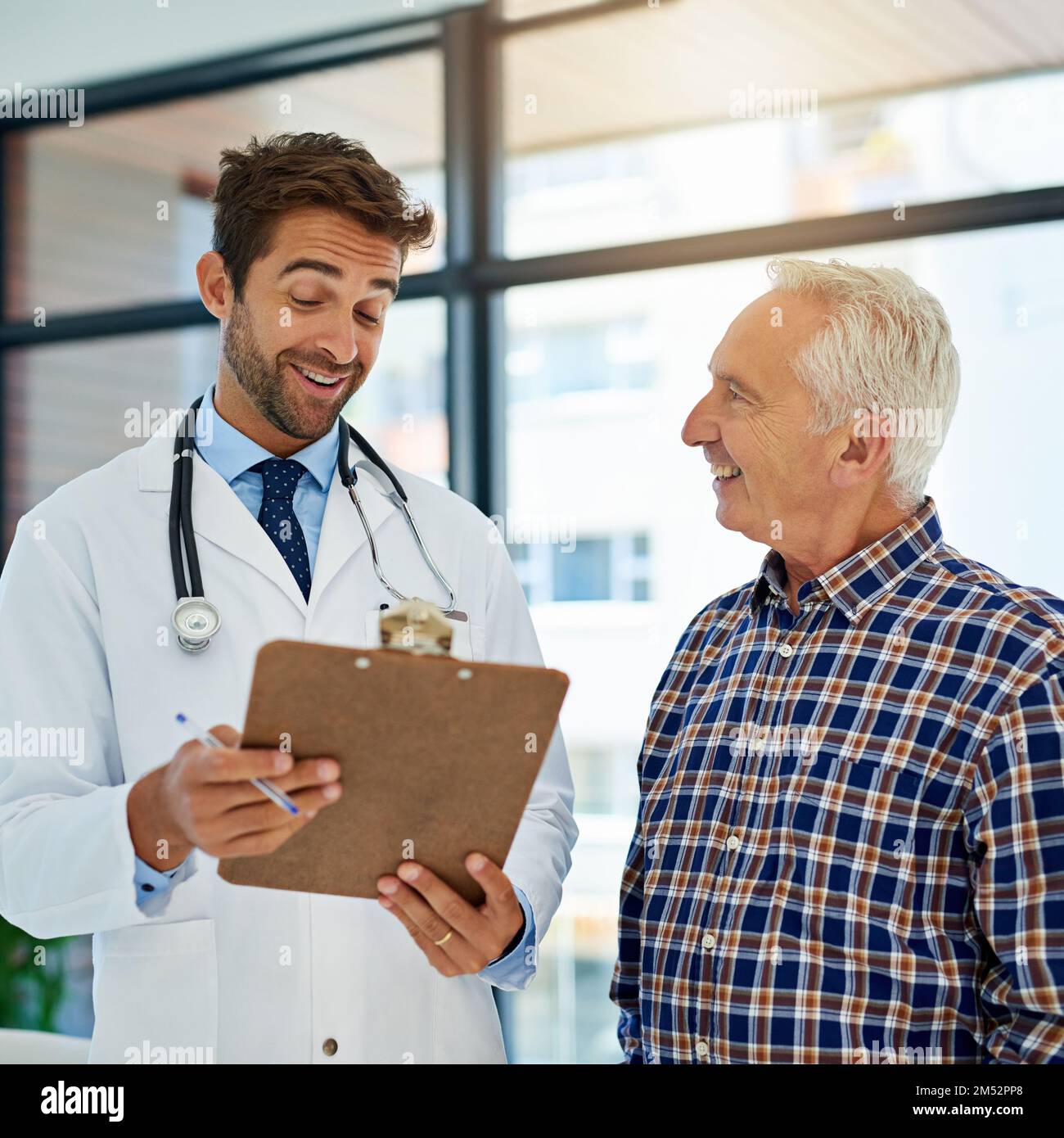 Nous n'avons vraiment pas pu demander de meilleurs résultats. un médecin joyeux partageant de bons résultats de test avec son patient mature à l'hôpital. Banque D'Images