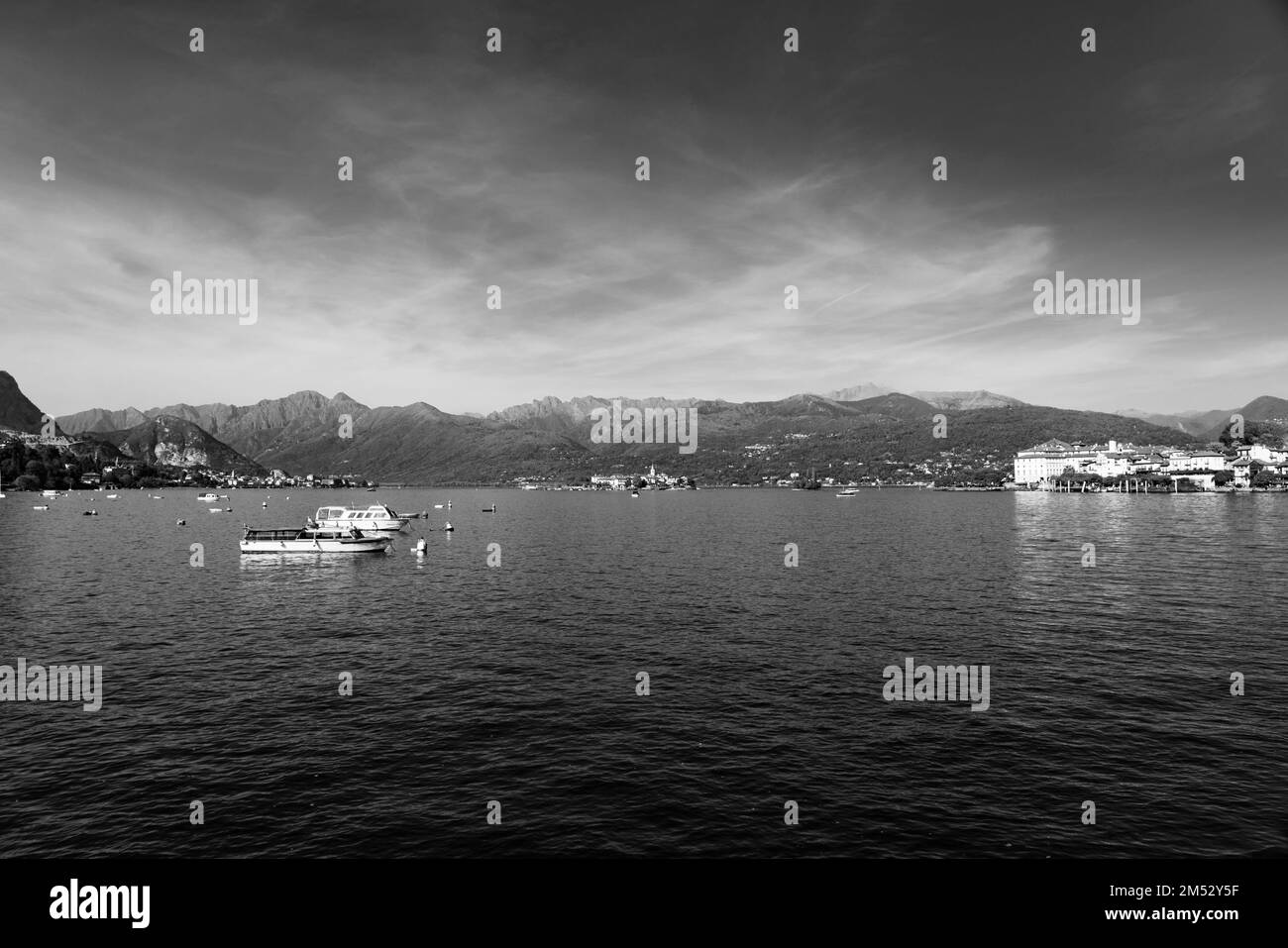 Petits bateaux en bois au lac majeur à Stresa, paysages sur le lac dans le fond des alpes, blanc noir Banque D'Images