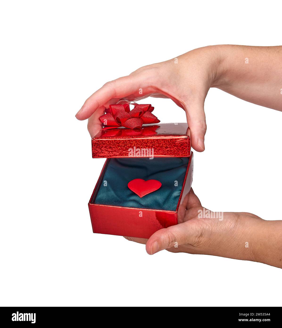 Une femme ouvre une boîte cadeau contenant un cœur rouge sur fond blanc avec un cœur rouge à l'intérieur, isolée sur fond blanc et un espace de copie. Concept d'amour, p Banque D'Images