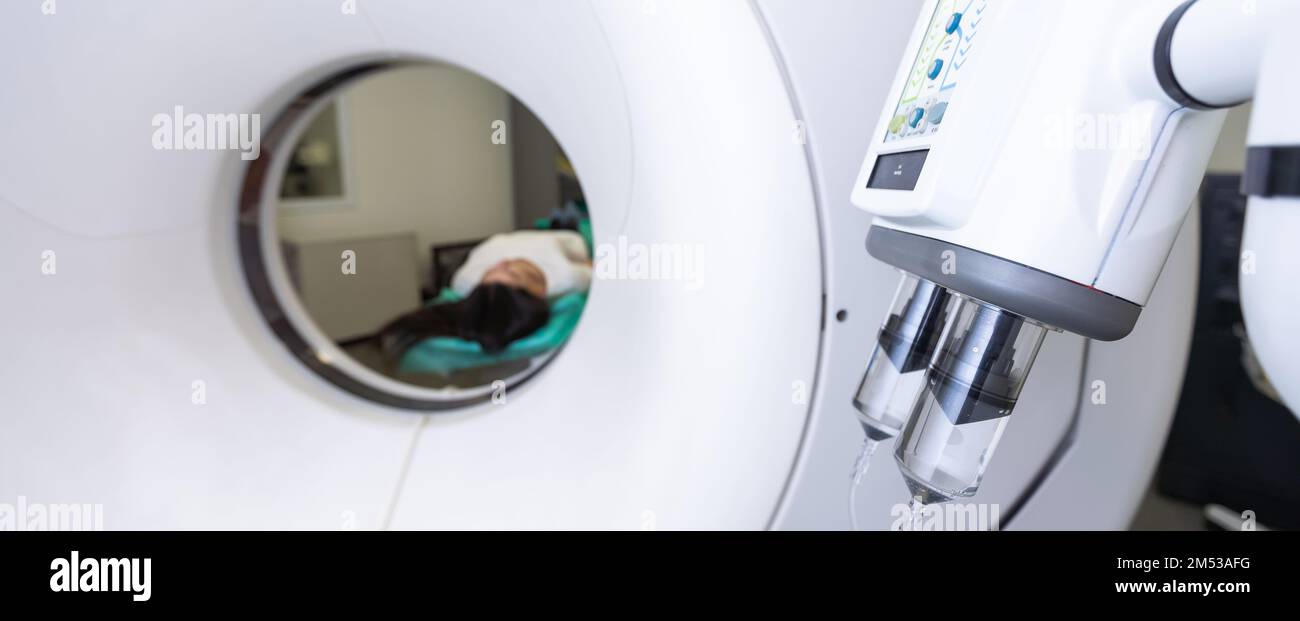 Un technologue en acquisition CT qui regarde le patient dans le scanner — free download