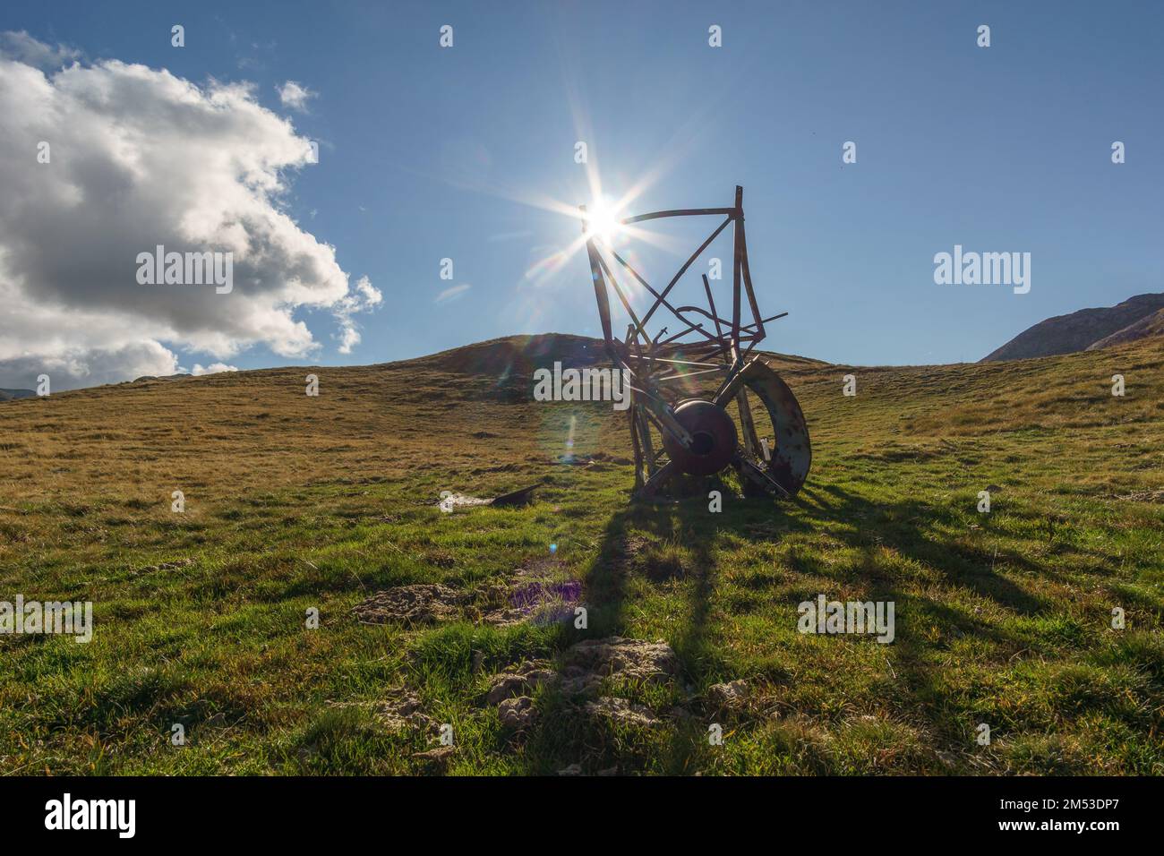 Ancienne structure métallique en acier rouillé abandonnée et détruite, posée sur un pré de montagne dans les pyrénées au soleil Banque D'Images