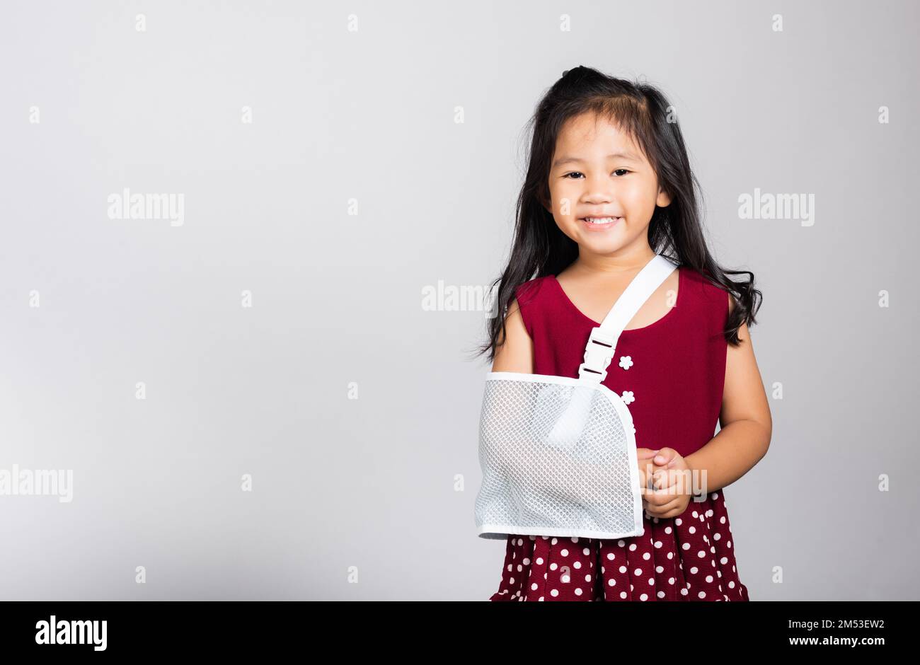 Petite petite fille mignonne 3-4 ans os de main cassé d'accident avec attelle de bras dans le studio tiré isolé Banque D'Images