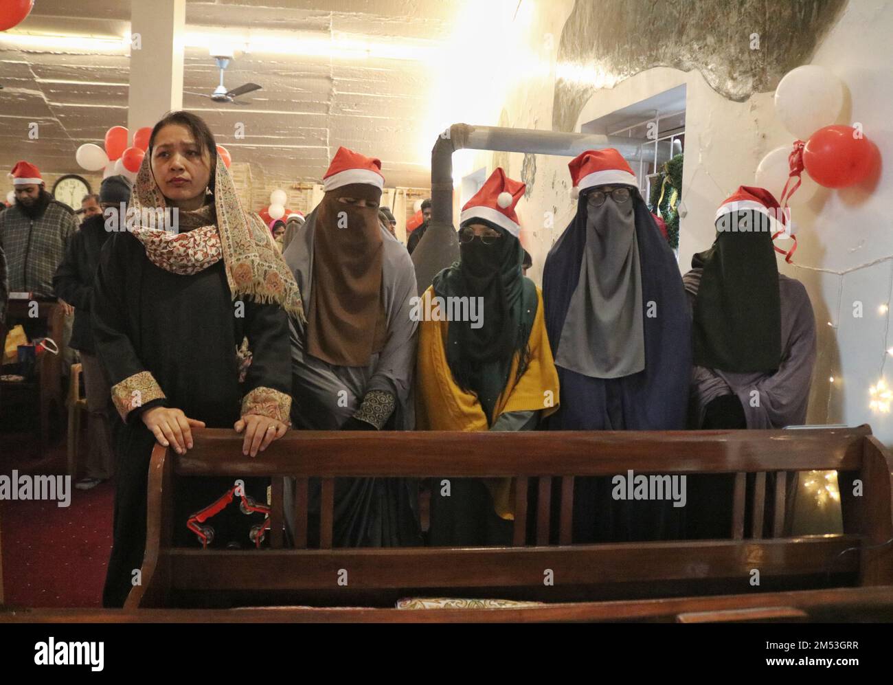 Les femmes musulmanes cachemiriennes voilées takae un selfie alors qu'elles assistent à la messe de Noël avec les chrétiens à l'intérieur de l'Église catholique de la Sainte famille tandis que les chrétiens assistent à la messe de Noël à l'intérieur de l'Église catholique de la Sainte famille sur 25 décembre 2022 à Srinagar, la capitale estivale du Cachemire administré par l'Inde. La région contestée de l'Himalaya du Cachemire a une population minuscule de chrétiens, dont des centaines se joignent à la masse à l'église catholique de la Sainte famille à Noël et prient pour la paix et la prospérité de la région. (Photo de Mubashir Hassan/Pacific Press) Banque D'Images