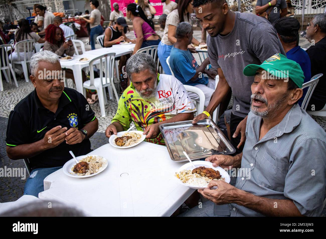 Rio de Janeiro, Brésil. 24th décembre 2022. Les bénévoles servent le dîner de charité pour les sans-abri le soir de Noël. Dîner de Noël pour les sans-abri dans le centre de Rio de Janeiro. 150 volontaires sous l'église baptiste se sont mobilisés sur la place Largo de Carioca pour servir le dîner de Noël pour les personnes qui vivent dans les rues du centre de Rio de Janeiro. Depuis 15 ans, l'église baptiste organise cet événement pour les sans-abri. Dans la deuxième plus grande ville du Brésil, environ 15 000 000 personnes vivent dans les rues sans domicile. Crédit : SOPA Images Limited/Alamy Live News Banque D'Images