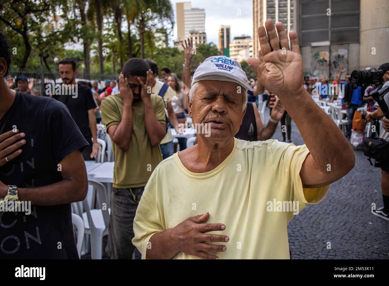 Rio de Janeiro, Brésil. 24th décembre 2022. Les sans-abri prient avant de recevoir un dîner de charité le soir de Noël. Dîner de Noël pour les sans-abri dans le centre de Rio de Janeiro. 150 volontaires sous l'église baptiste se sont mobilisés sur la place Largo de Carioca pour servir le dîner de Noël pour les personnes qui vivent dans les rues du centre de Rio de Janeiro. Depuis 15 ans, l'église baptiste organise cet événement pour les sans-abri. Dans la deuxième plus grande ville du Brésil, environ 15 000 000 personnes vivent dans les rues sans domicile. (Photo par Antonio Cascio/SOPA Images/Sipa USA) crédit: SIPA USA/Alay Live News Banque D'Images