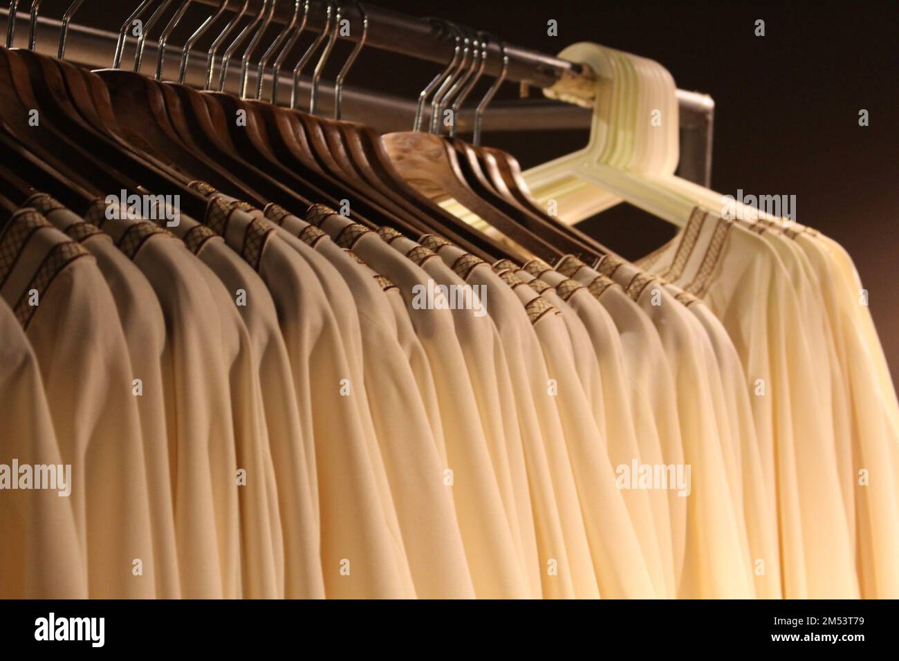 Une rangée de vêtements similaires suspendus sur un rack - concept de performance Banque D'Images