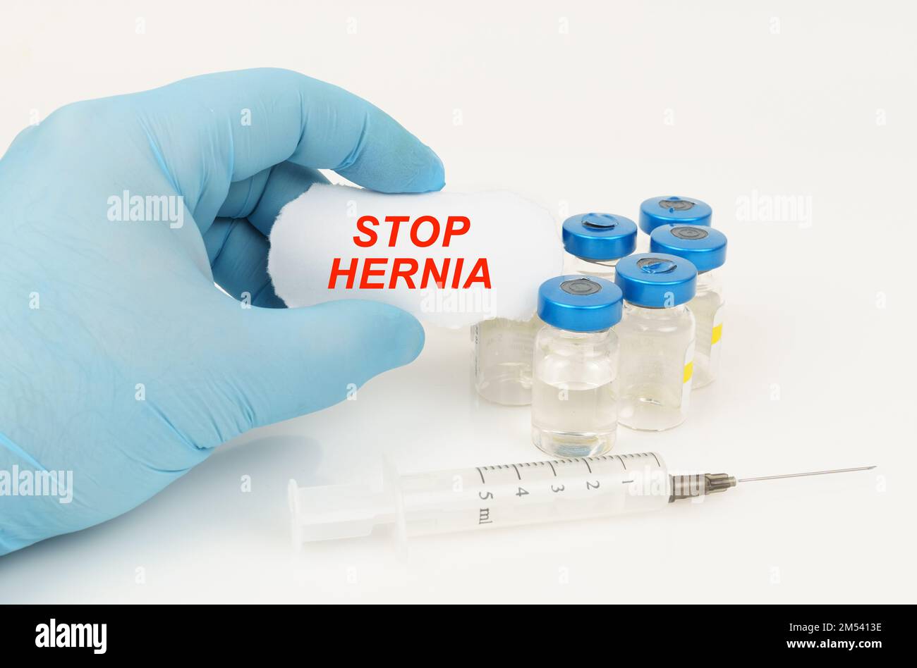 Concept médical. Dans la main de l'homme est un morceau de papier avec l'inscription - STOP HERNIE, à côté de lui se trouve une seringue et des pots d'injection. Banque D'Images Concept médical. Dans la main de l'homme est un morceau de papier avec l'inscription - STOP HERNIE, à côté de lui se trouve une seringue et des pots d'injection. Banque D'Images