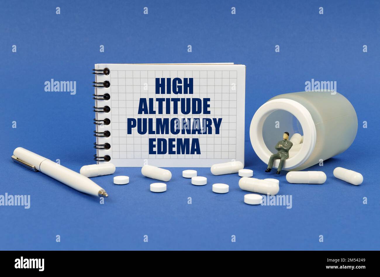 Concept médical. Sur une surface bleue, il y a un pot de pilules, une figure d'homme, un bloc-notes avec l'inscription - l'oedème pulmonaire de haute altitude Banque D'Images