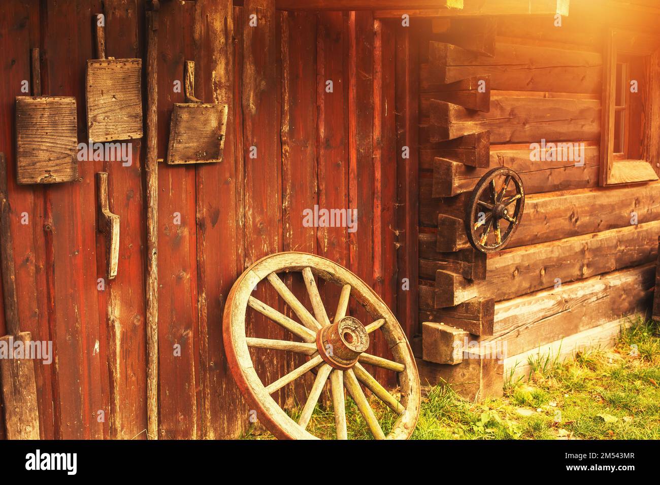 Vieux outils paysan accrochés sur un mur en bois sur une ferme animalière. Banque D'Images