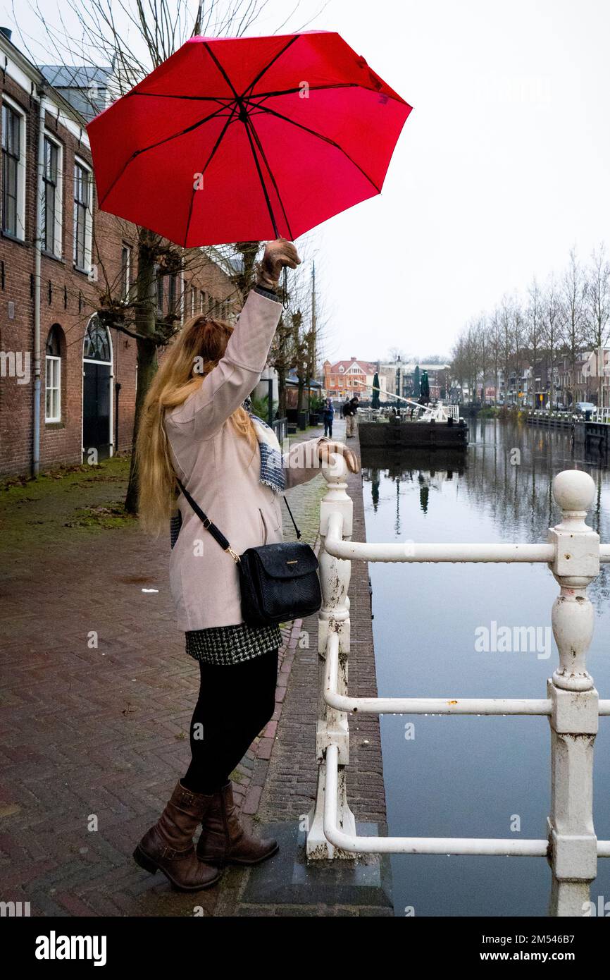 Femme avec parapluie rouge regardant la vue sur le canal, plein cadre Photo  Stock - Alamy