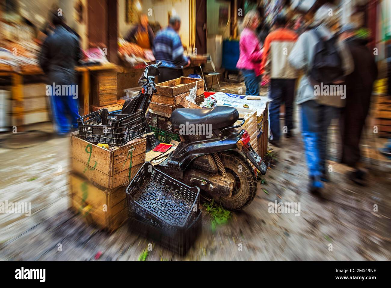 Mobylette garée entre des boîtes, foule anonyme dans le souk, effet zoom, image symbolique manque d'espace de stationnement, chaos, dynamique, Fes el Bali, Maroc Banque D'Images