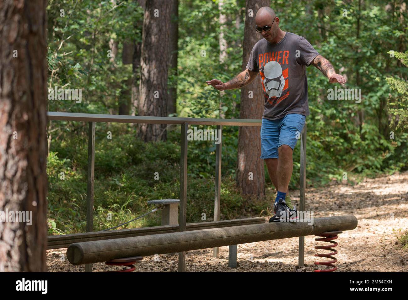 Homme en équilibre sur un faisceau sur une piste de découpage, Bavière, Allemagne Banque D'Images