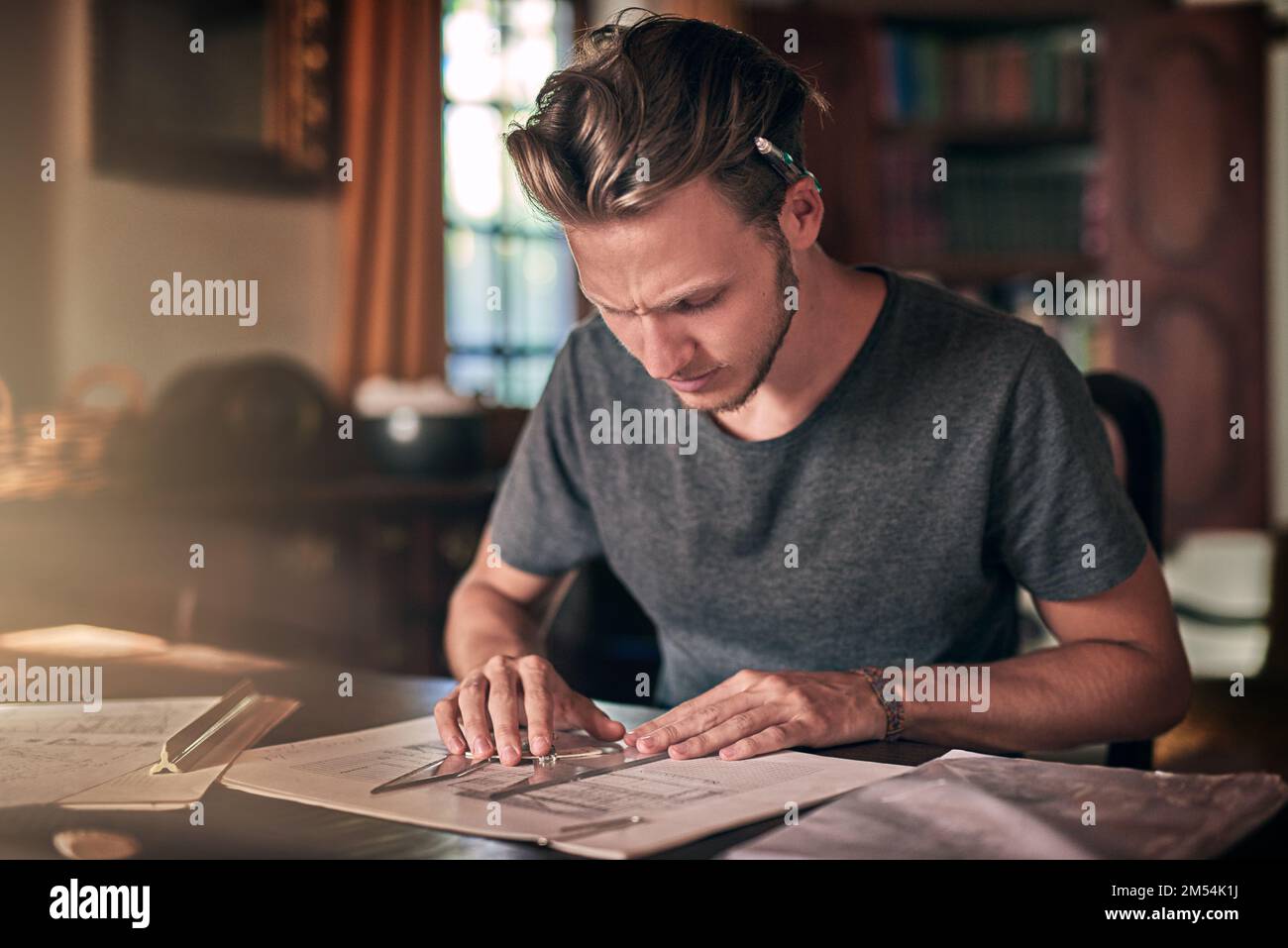 Attendez, ça ne peut pas être correct. un jeune étudiant diligent faisant un devoir à la maison. Banque D'Images