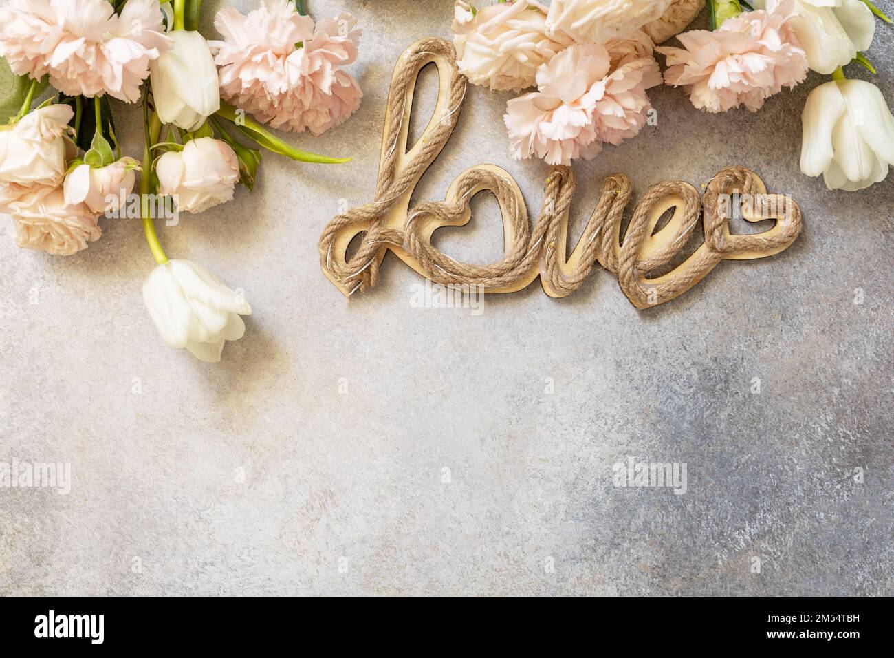 Carte de vœux de Saint-Valentin avec lettres « Love » et magnifiques fleurs printanières sur fond gris clair. Saint-Valentin, Fête des femmes, fête des mères conc Banque D'Images