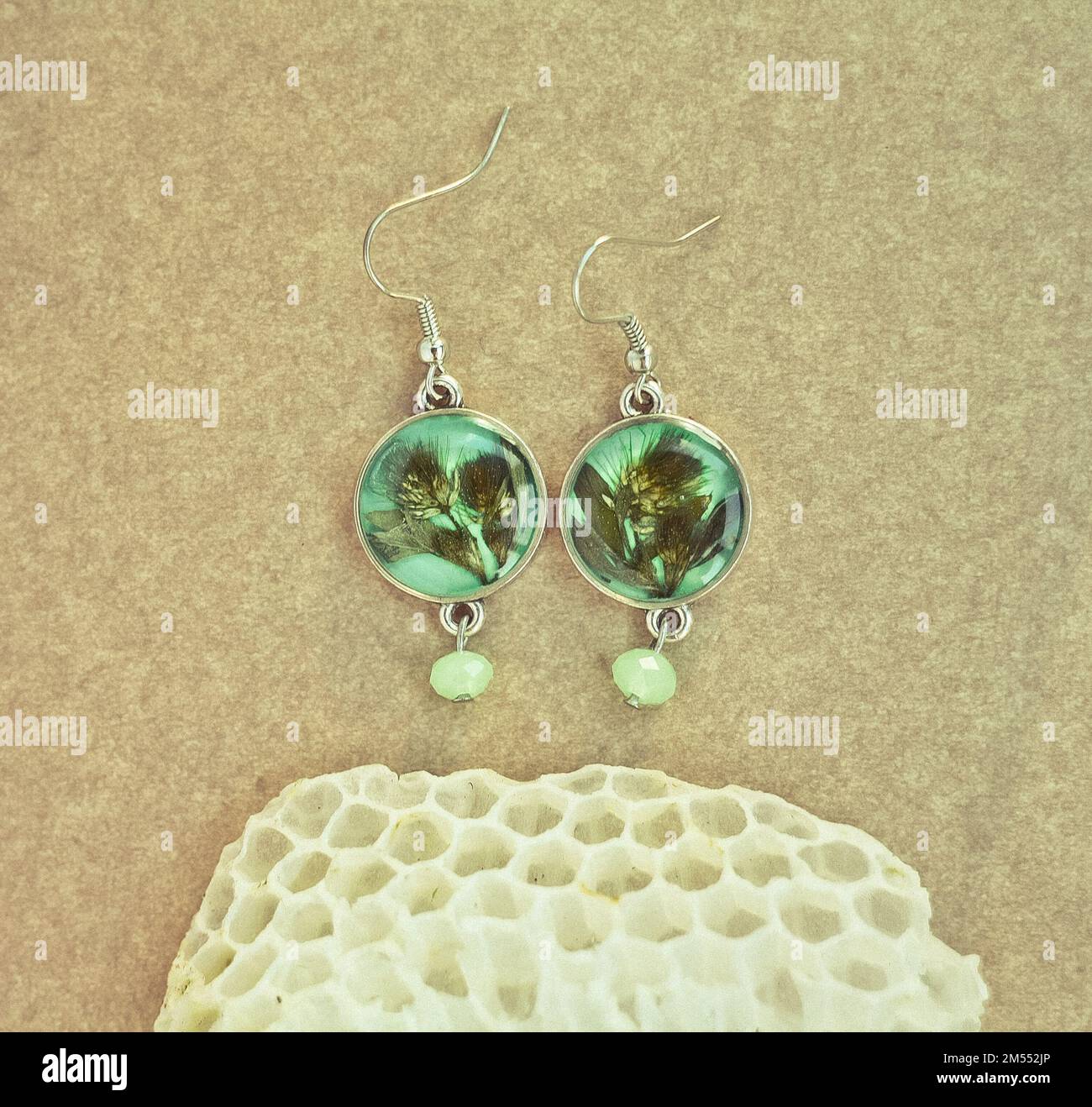 Gros plan boucles d'oreilles artisanales avec feuilles et nid d'abeille concept photo Banque D'Images