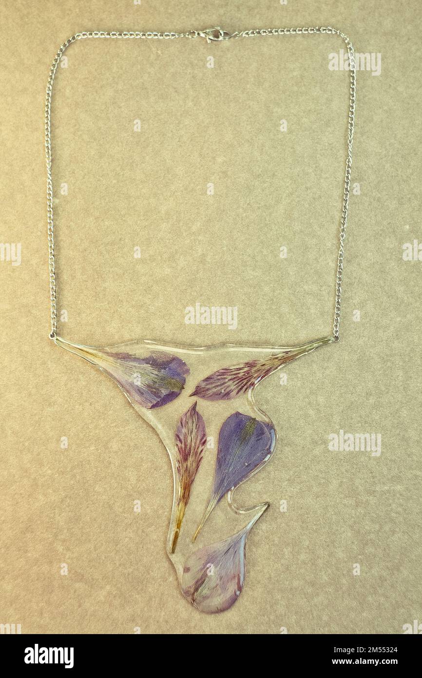 Gros plan sur une suspension faite à la main avec des pétales et une photo de concept en résine époxyde Banque D'Images