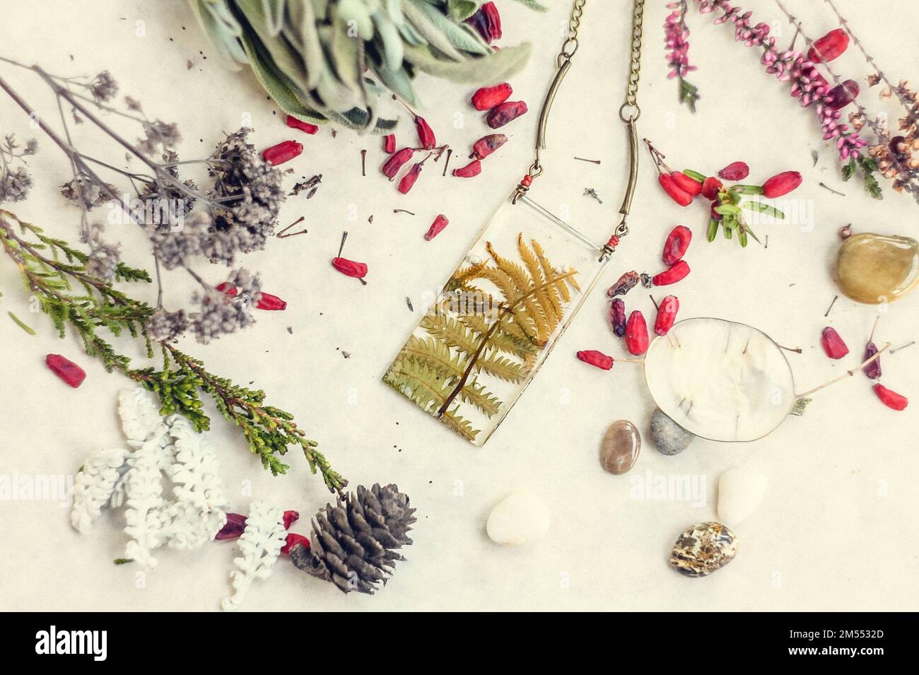Pendentif gros plan avec feuilles de fougères et éléments floraux concept photo Banque D'Images