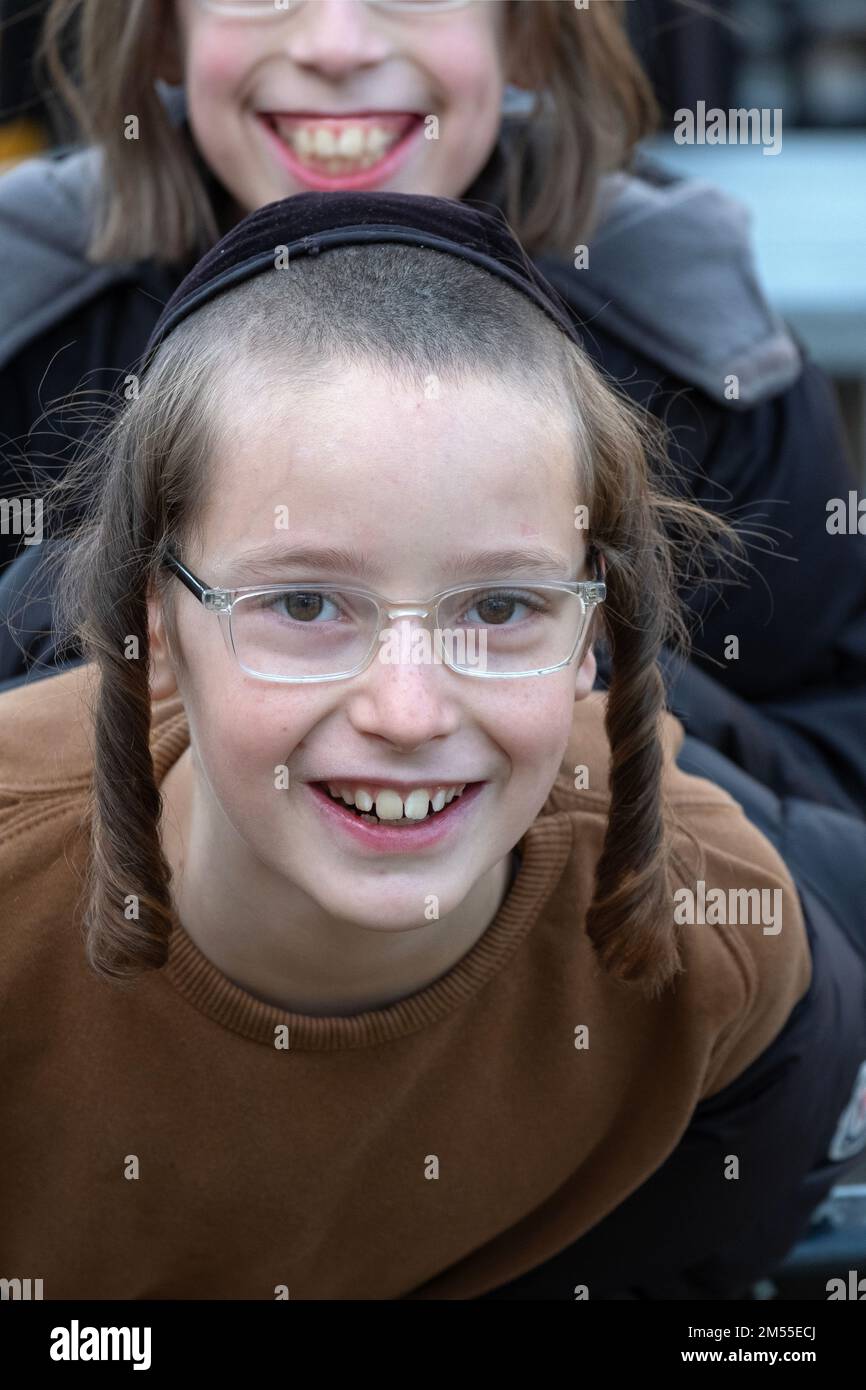 Deux enfants juifs hasidiques souriants avec peyus et un grand sourire pendant leur récréation scolaire. À Brooklyn, New York Banque D'Images