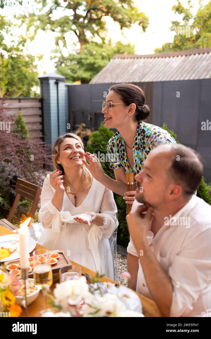 Beaucoup de gens disent des acclamations et montrent leurs verres à champagne plein de vin mousseux les uns aux autres tout en appréciant une fête de mariage en plein air sur un dos Banque D'Images