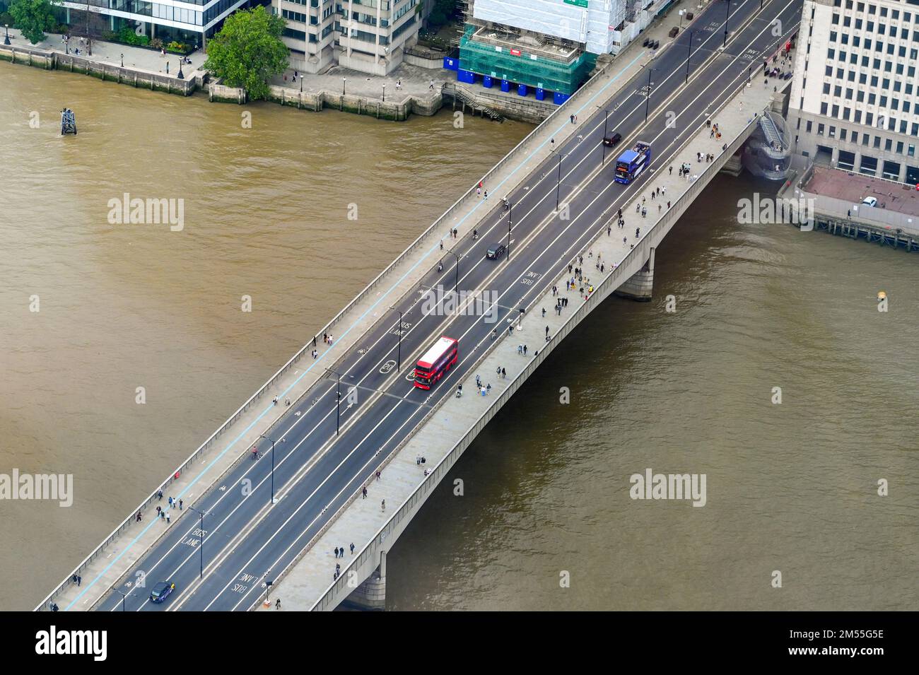 Londres, Angleterre - août 2021 : vue aérienne d'un bus à impériale rouge de Londres et de personnes traversant un pont au-dessus de la Tamise Banque D'Images