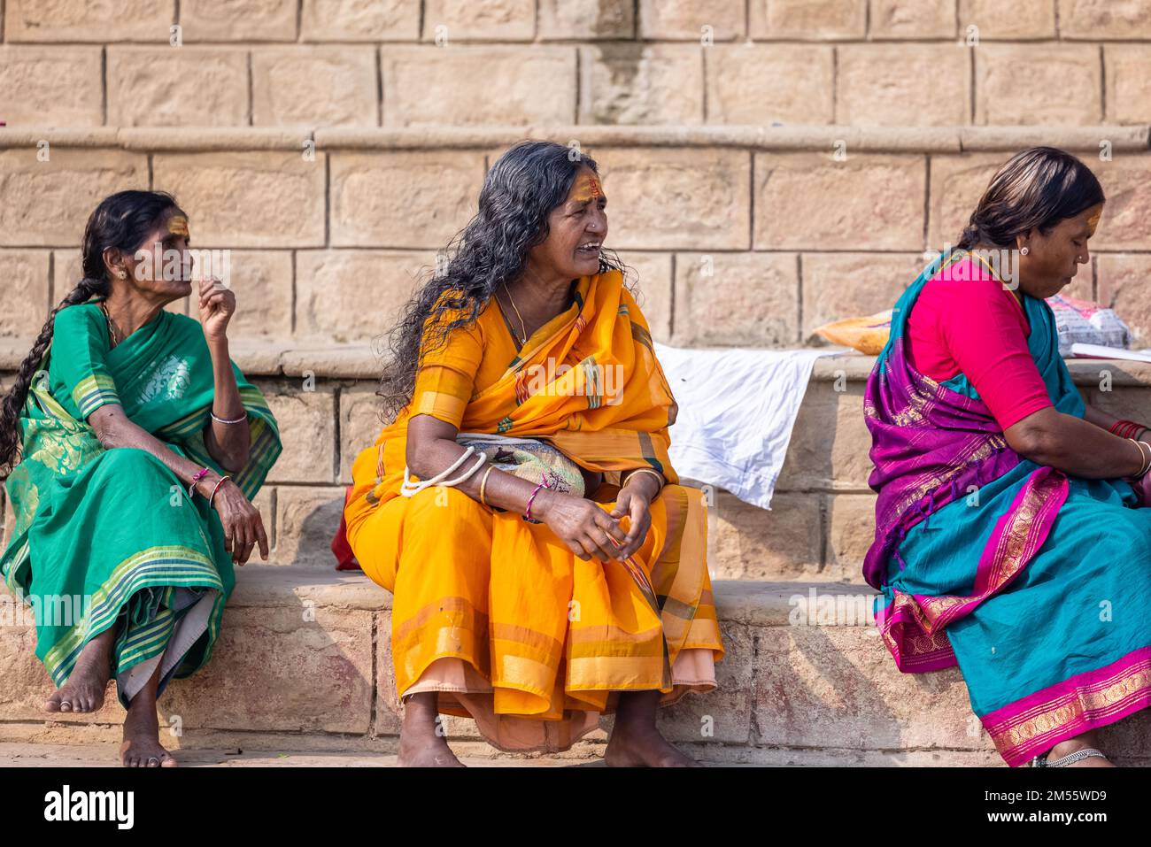 Varanasi, Inde: Portrait d'une vieille femme indienne du sud assise près de kedar Ghat dans une saree traditionnelle avec tête chauve. Mise au point sélective sur l'œil et le visage. Banque D'Images