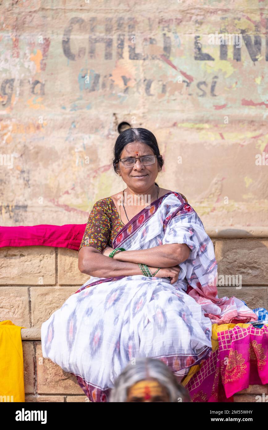 Varanasi, Inde: Portrait d'une vieille femme indienne du sud assise près de kedar Ghat dans une saree traditionnelle avec tête chauve. Mise au point sélective sur l'œil et le visage. Banque D'Images