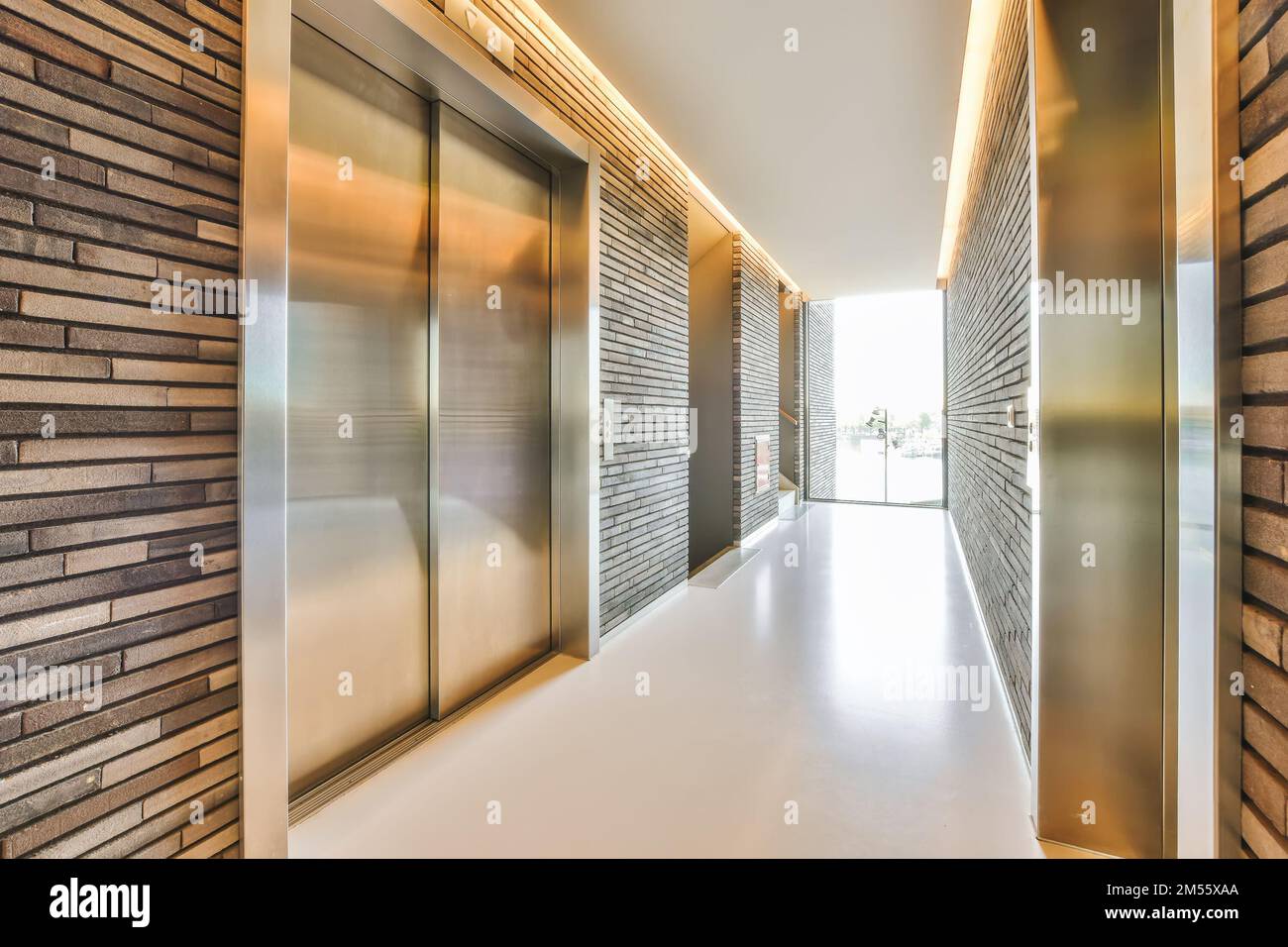 un couloir vide avec des panneaux de bois sur les murs et des portes en verre vous menant à une autre pièce dans cette maison moderne Banque D'Images